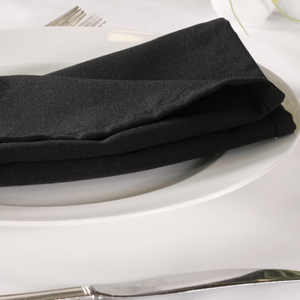 Black napkins folded on top of a plate.