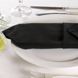 Black lieberspun napkins folded on a plate in a dressed up restaurant table 