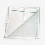 White bleached kitchen towel with green side on the borders, folded on a white background.