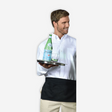 Men in a white shirt featuring a black apron and holding a tray with water bottle