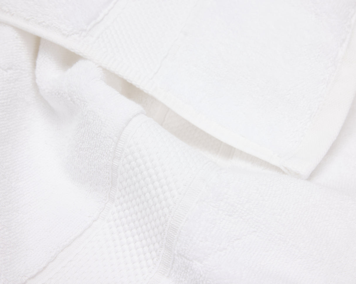 Close up view of a white hotel towel showing the elegant dobby border.