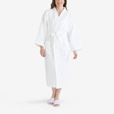Women wearing a white hotel bathrobe with white open slippers.