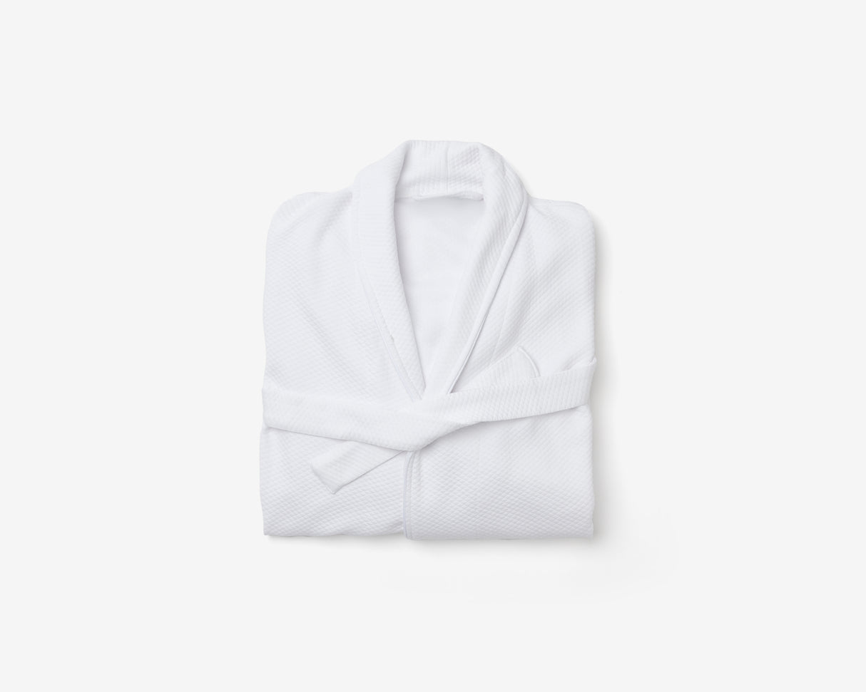 Folded white hotel bathrobe.