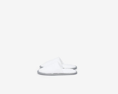 White closed toe kids slippers with a grey sole.