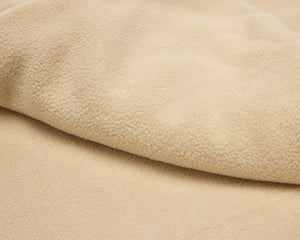 Beige polar fleece blanket.