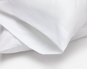 Close up look on a white pillow case, part of the hotel bed sheet collection.