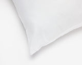 Close up view on the corner of a white hotel pillow.