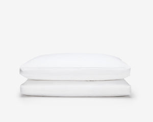 two white hotel box pillow, one on top of the other on a white background 