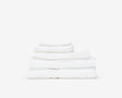 Folded white hotel towel placed on top of each other to form a pile.