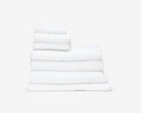 Folded white hotel towel placed on top of each other to create a pile.