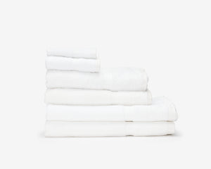 Folded white hotel towels placed on top of each other to form a pile.