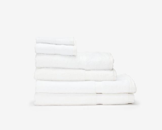 Folded white hotel towels placed on top of each other to form a pile.