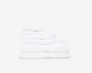 Pile of white hotel towels of different sizes.