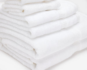 Close shot of a pile of white hotel towel folded on top of each other.