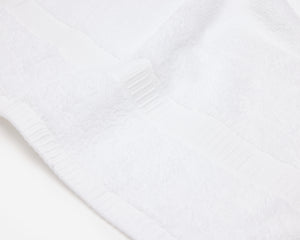 Close up picture of a white hotel towel with an elegant dobby border.