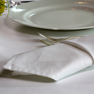 White satin band napkin placed on the dressed up table of the restaurant.