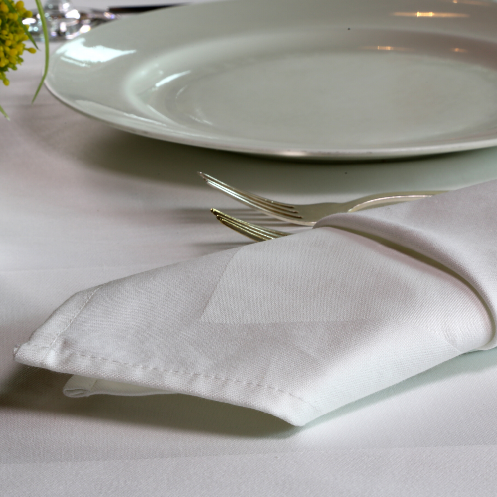 White satin napkin folded on a dressed up restaurant table.
